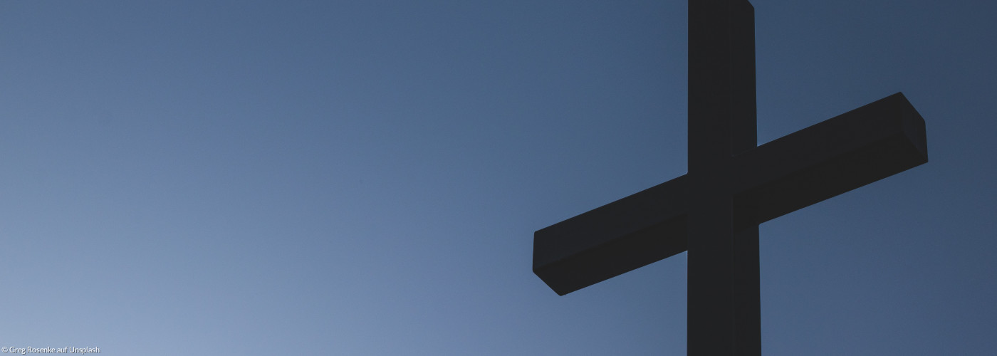 Kreuz vor blauem Himmel